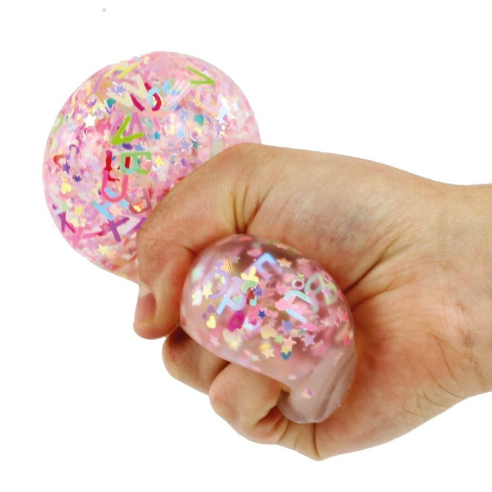Alphabet Glitter Ball 60mm, Give your child a sensory experience like no other with the Alphabet Glitter Balls. These irresistible, gel-filled balls serve multiple purposes—from stress reduction and hand strengthening to providing a delightful fidgeting experience. Filled with shiny, miniature alphabet letters suspended in a durable, clear cover, these balls are both educational and incredibly fun to play with. Alphabet Glitter Ball 60mm Features: Sensory Experience: The Alphabet Glitter Balls are designed 