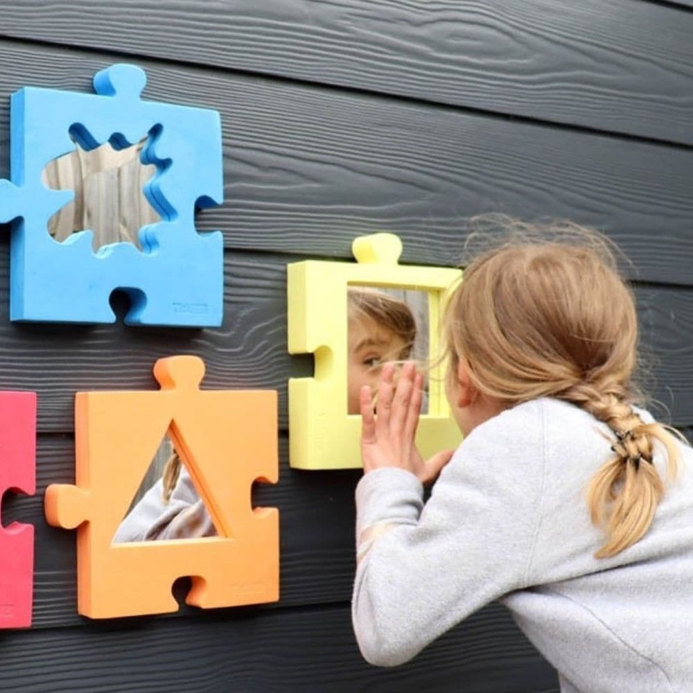 Jigsaw Softie Mirrors, Colourful Set of four Jigsaw Softies play mirrors with a jigsaw profile in four different colours, each measuring 200mm square. The Jigsaw Softie mirrors can be hand-held, free-standing, or wall-mounted to create a stunning, colourful display. The plane acrylic mirrors in a jigsaw-shaped foam surround allow your child to explore their reflection and add an element of intrigue as they use them to investigate reflection in their environment. Ideal as part of a sensory display or soft pl