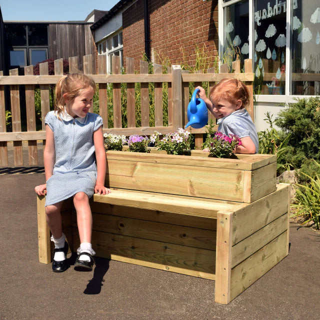 Outdoor Wooden Double-Sided Bench Planter, The Outdoor Wooden Double Sided Bench Planter is a remarkable addition to any outdoor play area. Its unique design allows for up to 3-4 children to comfortably sit on each side, fostering a collaborative and social environment. This bench planter not only provides a seating area, but also creates an opportunity for children to nurture their affinity for nature and the outdoors. The interactive nature of this resource encourages little ones to engage in planting, po