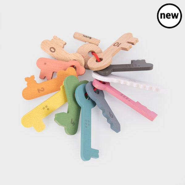TickiT Rainbow Keys Pack of 11, The TickiT® Rainbow Wooden Counting Keys are an engaging and educational tool for children. Crafted from smooth, solid beechwood, the keys boast a natural woodgrain finish, painted in seven vibrant rainbow colours, along with black, white and natural.Each key is uniquely designed and numbered from 0-10 on one side, with the corresponding number of dots on the reverse. This feature aids in improving your child's counting, sorting and sequencing skills. The tactile keys also he