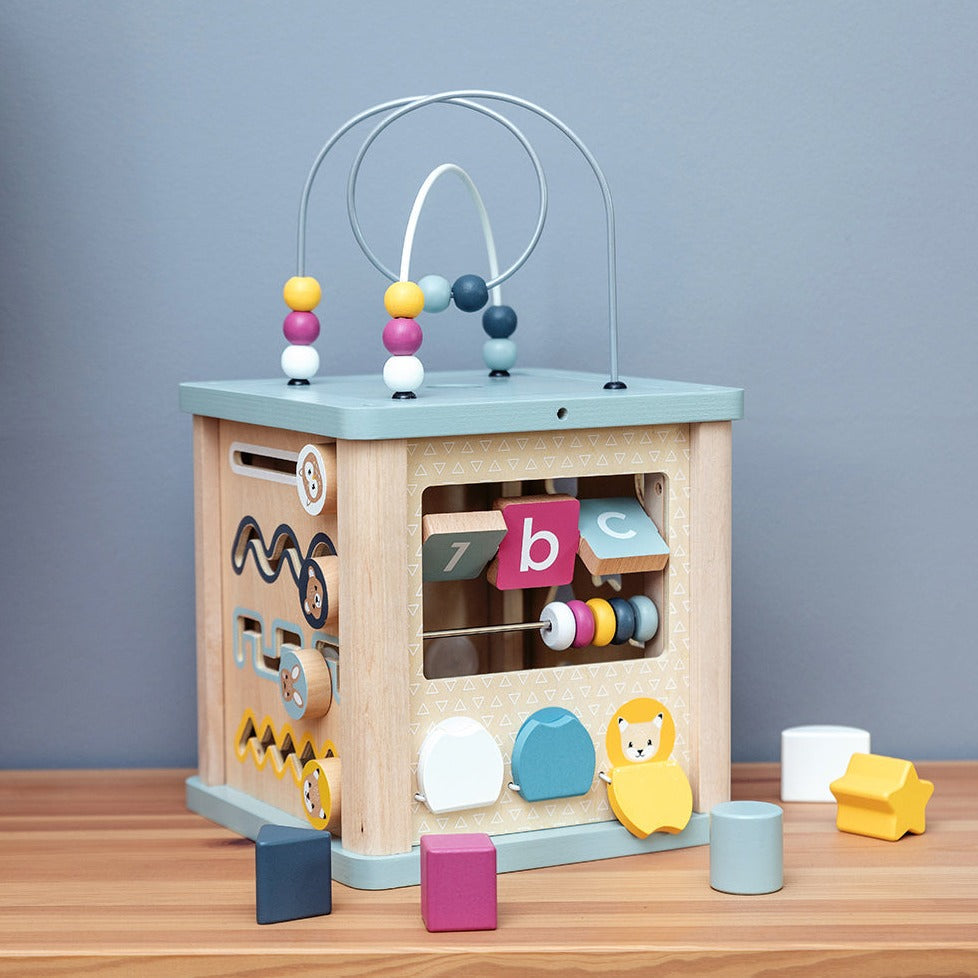 100% FSC Certified Activity Cube, Tots will be entertained for hours with our 100% FSC Wooden Activity Cube. Each of the four sides are packed full of different activities to help youngsters learn through educational play. Activities include: a shape sorter, a bead coaster, wooden cogs and much more. The soft colour palette makes this wooden baby toy suitable for both girls and boys. The wooden activity cube is perfect for developing toddlers’ social, communication and numeracy skills as they twist, spin, a