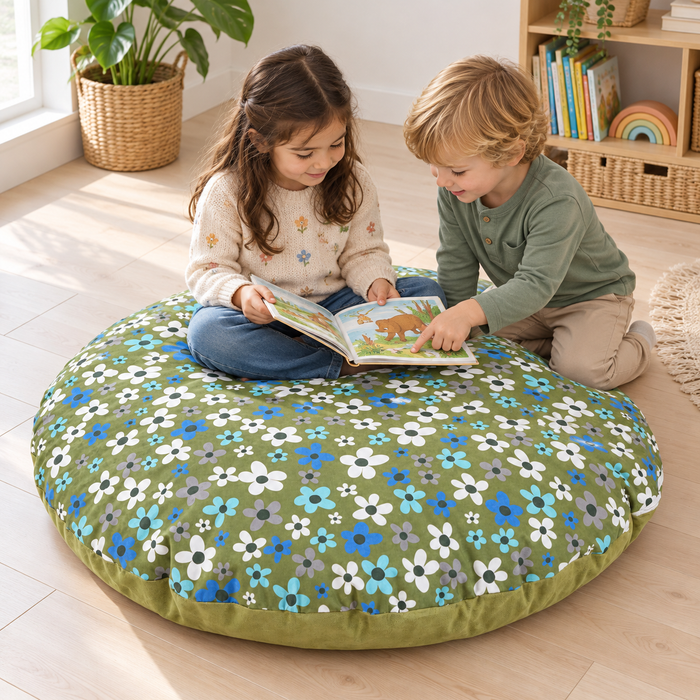 Two children sharing a book with the round floor cushion