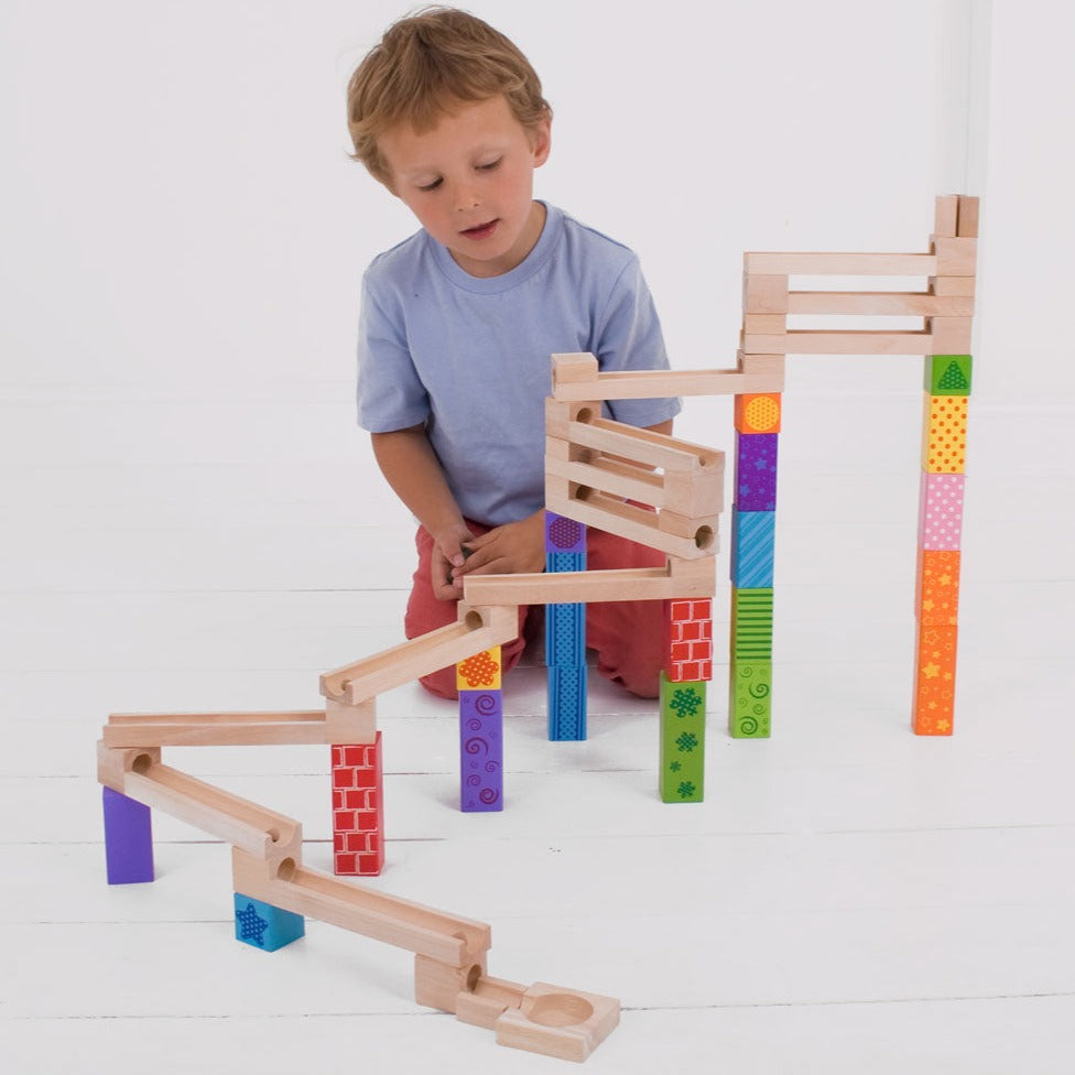 Bigjigs Toys Marble Run, Little builders can construct an impressive colourful Wooden Marble Run with this fun wooden toy! Place your marbles at the top and watch in delight as they roll down to the bottom! With 53 play pieces to choose from, there are endless possibilities for our marble run toy! The multicoloured printed blocks allow small hands to create funky designs. A fantastic way to encourage dexterity, hand-eye coordination and creativity. The Bigjigs Toys Marble Run is perfect for creative play se