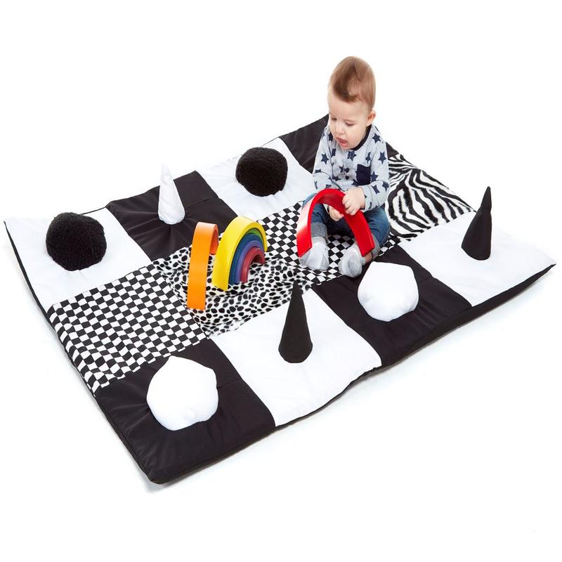 Black & White Sensory Contrasts Mat, The Black and White Sensory Contrasts Mat is a must-have for any early years setting. This comfortable and soft mat is designed with contrasting black and white motifs, making it a captivating visual resource for babies.The mat features raised bumps and cones, providing both texture and sound for sensory stimulation. Babies will love exploring the different sensations as they touch and feel the unique patterns on the mat.What sets this mat apart is the flap that allows y