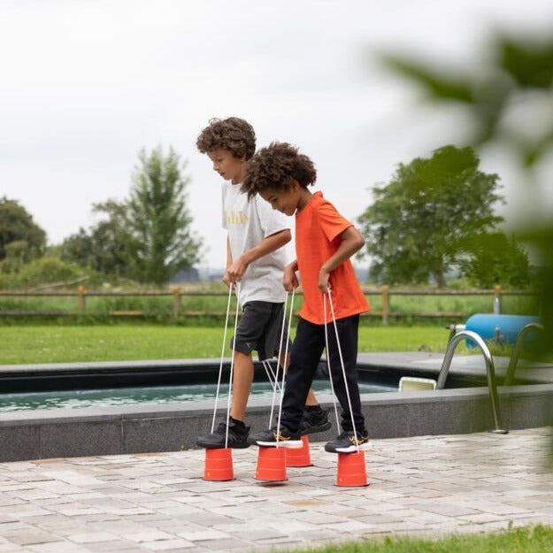 Bucket Balance Stilts, Launch your outdoor stomping fun to whole new heights with the Bucket Balance Stilts High quality braided polypropylene line is used for the handles to ensure durability and a good grip for little hands while strong plastic keeps you always up and never falling. After just a few steps, you'll be thinking, "why would I ever want to walk at my original height again?" With a 5 inch rise you'll get a whole new view of your entire world. Teach kids to bring cups out of the kitchen and into