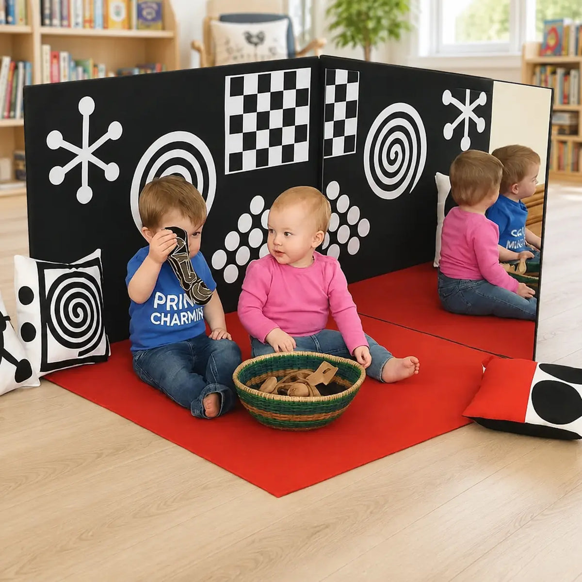 Curiosity Corner sensory panels and red play mat in a nursery reading area