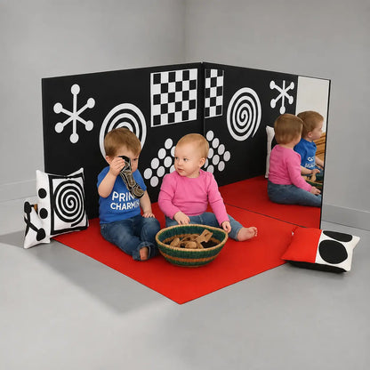 Curiosity Corner sensory panels and red play mat in a neutral studio room