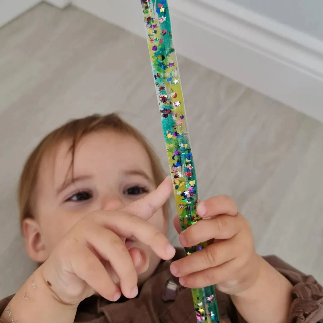 Dazzle Glitter Tube, The Dazzle Glitter Tube is a mesmerising long, tough acrylic tube filled with colourful rainbow glitter and small star shapes that creates a cascade effect throughout the wand when it is turned over. Creating a rhythmic flow and motion the shiny contents swirl and sparkle along the Glitter Tube. The Glitter Tube is a fantastic tool for tracking and focus skills, and will amaze children of all ages. A wonderful and robust multi-sensory resource. One supplied,measuring 32cm Magic tube sen