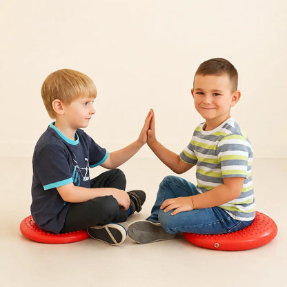 Disc O Sit Junior red inflatable seating cushions used by two children in a neutral studio