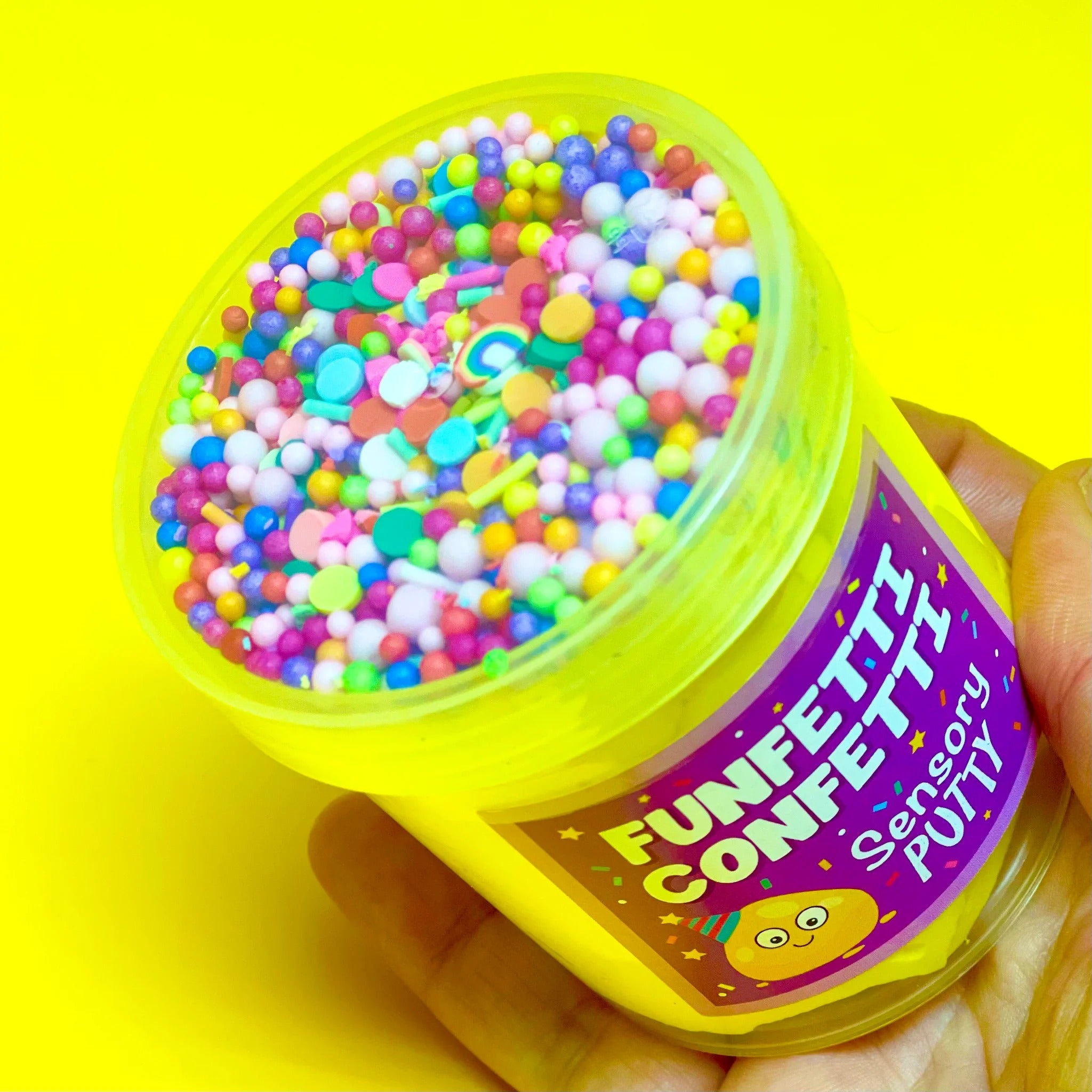 Funfetti Confetti Putty, It's time to celebrate with our funfetti confetti putty! Filled to the brim with rainbow sprinkles, floam balls and stars, that mix perfectly with our gentle sweet scent, yellow putty to create a sensory party in a pot! Putties are air reactive and will dry out of left out. Always return to the container after play with the lid tightly on. Keep away from direct sunlight. Keep away from fabrics and porous surfaces. Container Size: 275ml Ages 5+, Adult supervision recommended. Funfett