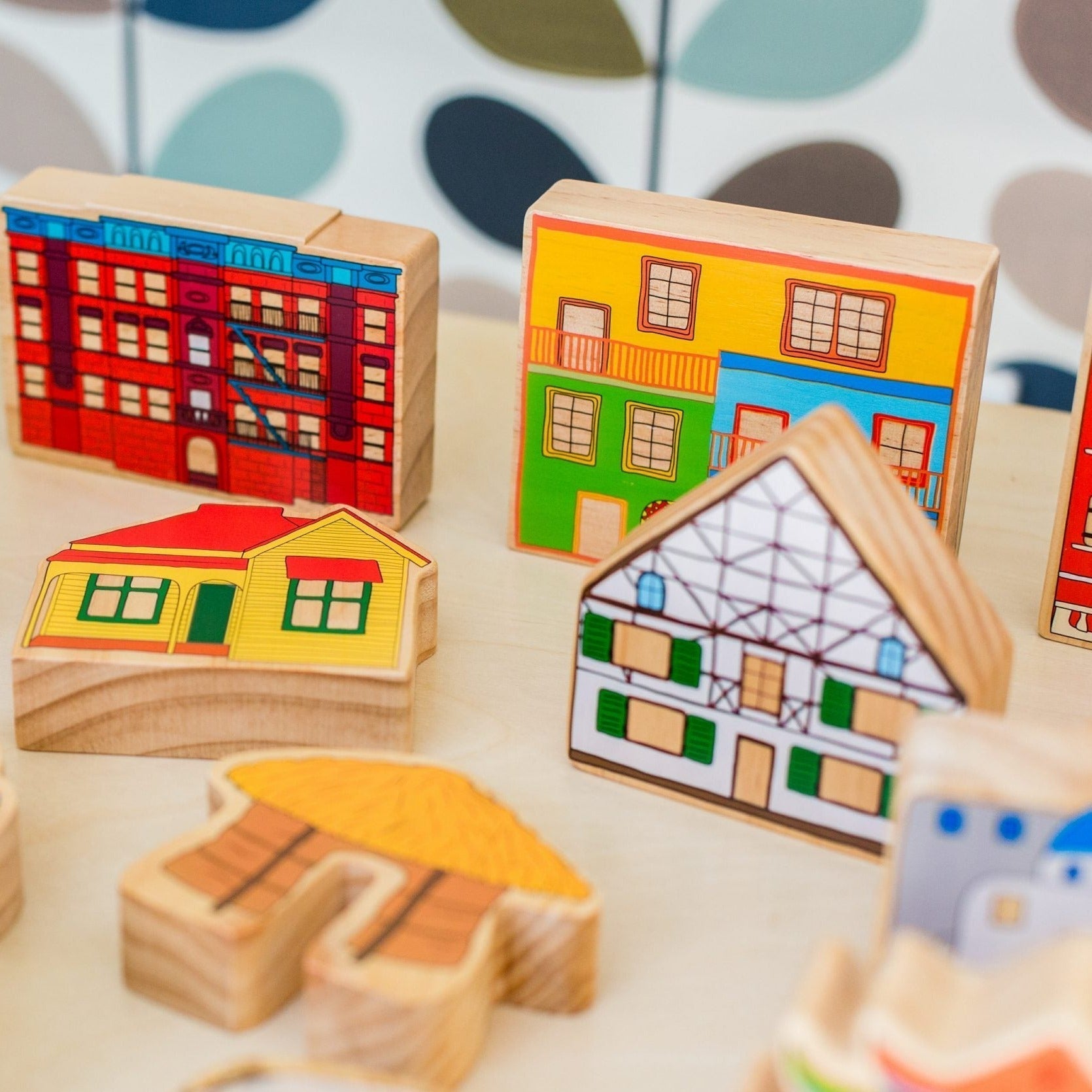 Homes Around the World, Introducing the Freckled Frog Homes around the World wooden block set - a beautifully illustrated and vibrant toy that sparks discussion about inclusion and communities while celebrating the diverse cultures and homes found around the globe. This set includes 15 blocks, each representing a different culture and country, such as Greece, Germany, South America,and China, among others.These wooden blocks are not only visually stunning but also serve as a tool for children's creative pla