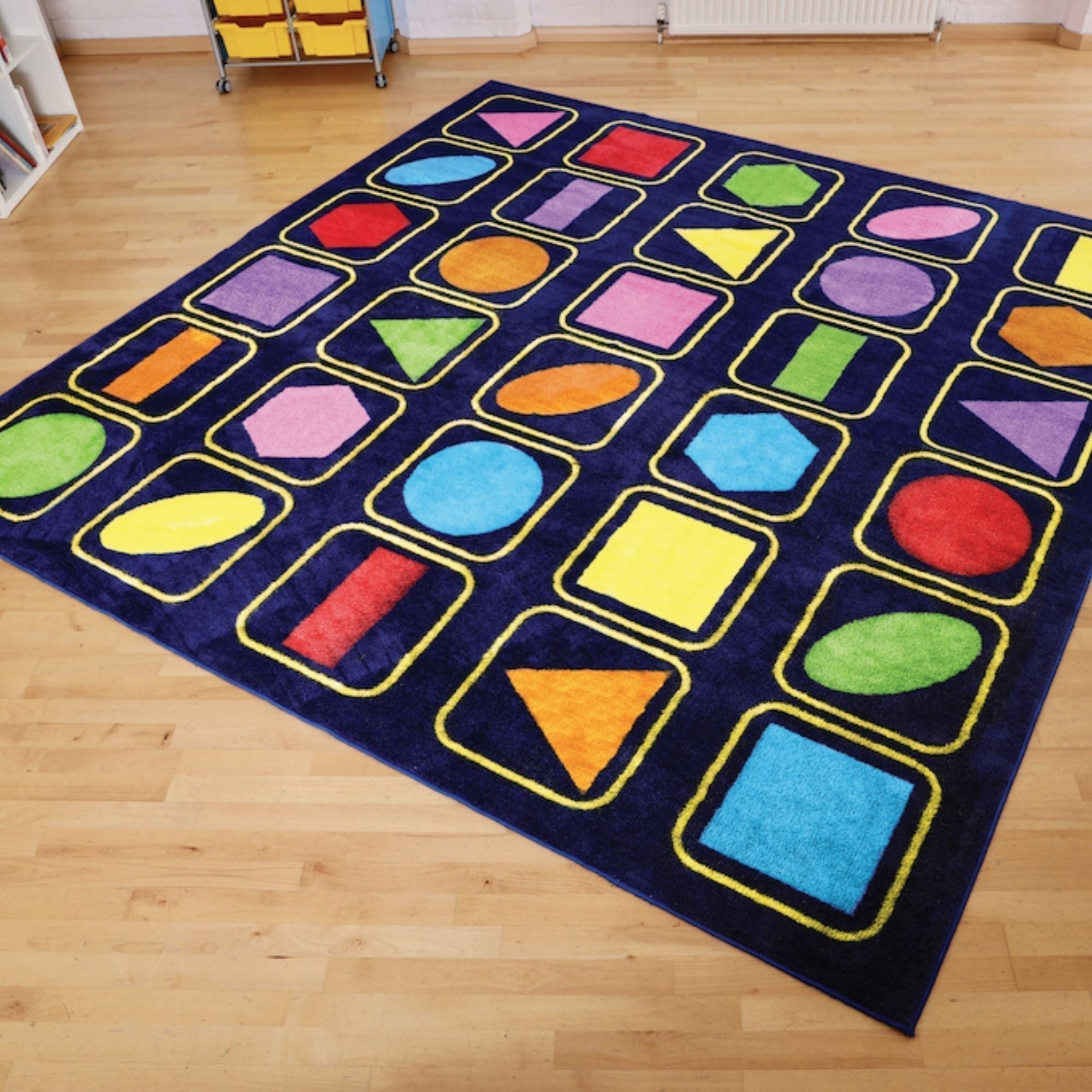 Kindercolour Geometric Shapes Carpet 3 X 3 Metre, The Kindercolour™Geometric Shapes Carpet is a huge 3m square placement carpet with clearly recognisable seating areas for up to 30 children. These brightly coloured basic shapes aid shape and pattern identification. Heavy duty Dura-Pile™, substantial premium quality carpet, with an extra thick pile. Soft textured, tufted Nylon twist pile, designed specifically for comfort and longevity. Ideal for early years and primary school learning environments. Tightly 