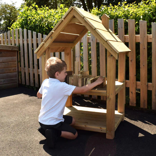 Outdoor Building Blocks House, The Outdoor Building Blocks House is a fantastic resource that allows children to engage in both maths and construction play. This well-designed and manufactured product is a great addition to any early years playground. With its storage shelf, children can not only have fun building and creating but also develop vital social interaction skills and fine motor skills. This Outdoor Building Blocks House provides an enriching and enjoyable learning experience for children of all 