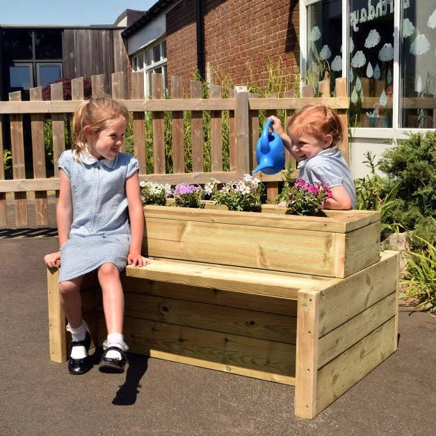 Outdoor Wooden Double-Sided Bench Planter, The Outdoor Wooden Double Sided Bench Planter is a remarkable addition to any outdoor play area. Its unique design allows for up to 3-4 children to comfortably sit on each side, fostering a collaborative and social environment. This bench planter not only provides a seating area, but also creates an opportunity for children to nurture their affinity for nature and the outdoors. The interactive nature of this resource encourages little ones to engage in planting, po