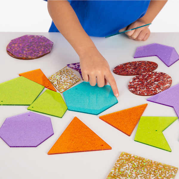 Rainbow Glitter Shapes, Our TickiT Rainbow Glitter Shapes set contains a range of dazzling acrylic shapes in the 7 colours of the rainbow. Your child will be captivated as they watch how the shapes sparkle in the light and will be keen to explore the different configurations.Each colour includes 3 styles of a polygon and both irregular and regular shapes. The Rainbow Glitter Shapes are a fascinating and fun way to understand basic geometry and create interesting patterns and sequences. Ideal to use with a l