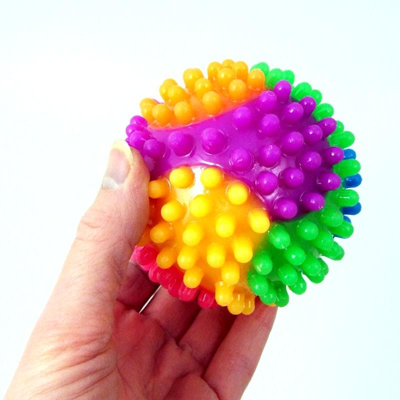Rainbow Spikey Ball Light Up, The Rainbow Spikey Ball Light Up is one colourful stress ball with a spikey texture to match! This rubbery, spiked-out, light-up ball is great for relieving your stress and for adding colour to your sensory collection, while at the same time the spikes will hit all the relaxing pressure points when you grab and squeeze it. To help you relax during a stressful moment, bounce the ball to activate its flashing light show. Then, watch the colourful blinking lights, zone out, and fo