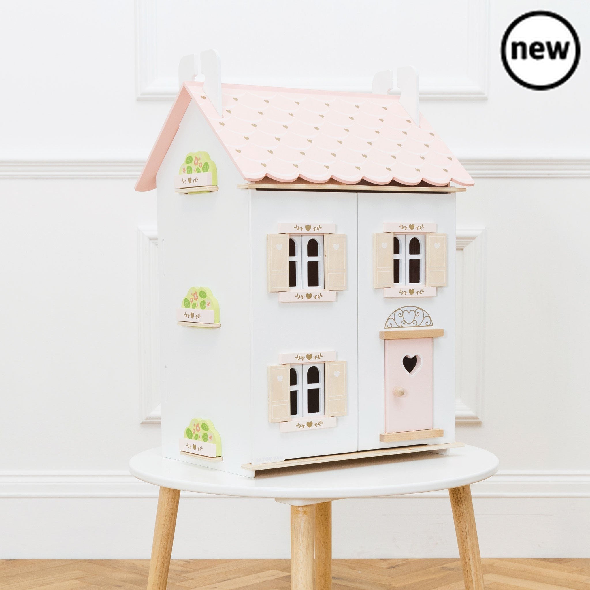 Rose Heart House, Description Welcome home. This delightful dolls house makes a stunning gift for a special little someone. Painted in fresh white with soft pink accents and gold heart motifs, it is ready to move right in to. Crafted from sustainable FSC® - certified wood, this durable, high quality toy features a scalloped roof, opening and closing doors and shutters for realistic play, plus a clever lift off roof that reveals access to a sweet attic bedroom. Inside, the floors are furnished in a lovely na