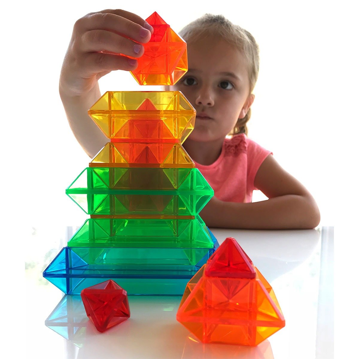 Sakkaro, Sakkaro is a geometry toy that will light up a child's creativity! It's translucent coloured pieces seem to magically blend together when you stack, nest and interlock them. Discover an endless variety of colourful shapes and patterns you can make on your own, or be inspired by our Idea Booklet which shows over 100 colourful patterns and shapes to make. Sakkaro is fun for the whole family. An amazing geometry resource which will light up a child's creativity! 15 translucent coloured pieces magicall