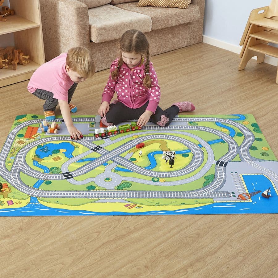 Small World Railway Themed Play Mat, Create an immersive play experience with the Small World Railway Themed Play Mat. This play mat is designed to transport children into a small world of imaginative play, where they can create their own railway adventures. The mat features a charming figure of 8 track in the center, providing a starting point for endless possibilities. Made from high-quality 100% polyester, the surface of the play mat is durable and easy to clean. The rubber anti-slip backing ensures that