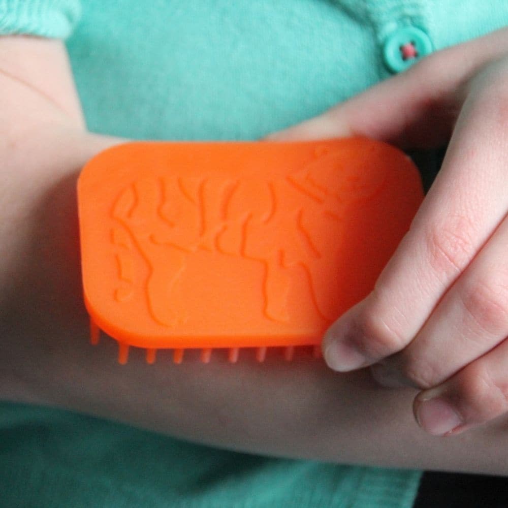 Tactile Tiger Brush, The Tactile Tiger Brush weighs in at roughly the size of a credit card but packs a huge sensory punch. Offering a bristled tactile surface as well as a raised surface tiger on the top side. The Tactile Tiger Brush is great for therapist, parent, or individual child use. This Tactile Tiger Brush will prove to be a great calming agent for any child or adult seeking sensory or tactile stimulation. The material of this hand fidget is FDA approved so it is safe if used as a oral motor device